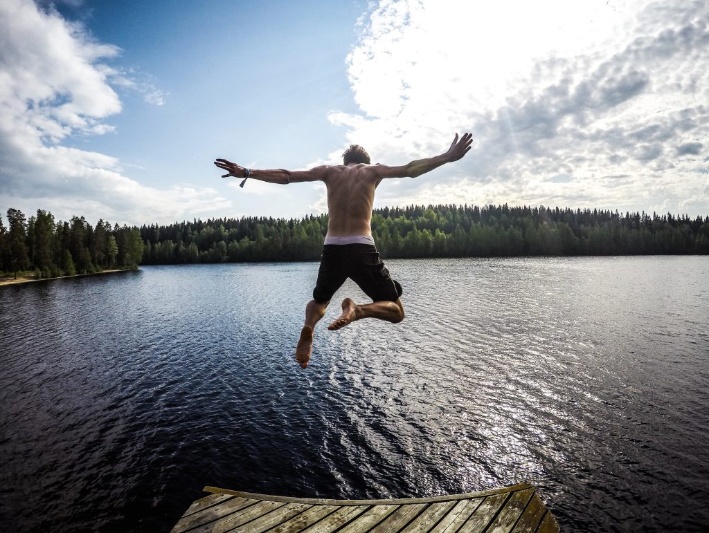 Man leaping into a lake, free from anxiety and into a meaningful life, enthusiastically