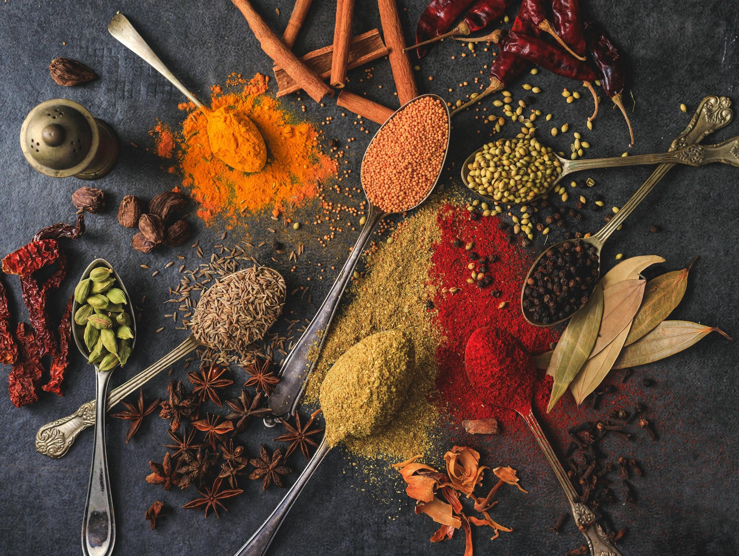 An array of whole and ground spices, symbolising Therapy for spiritual crisis guiding integration