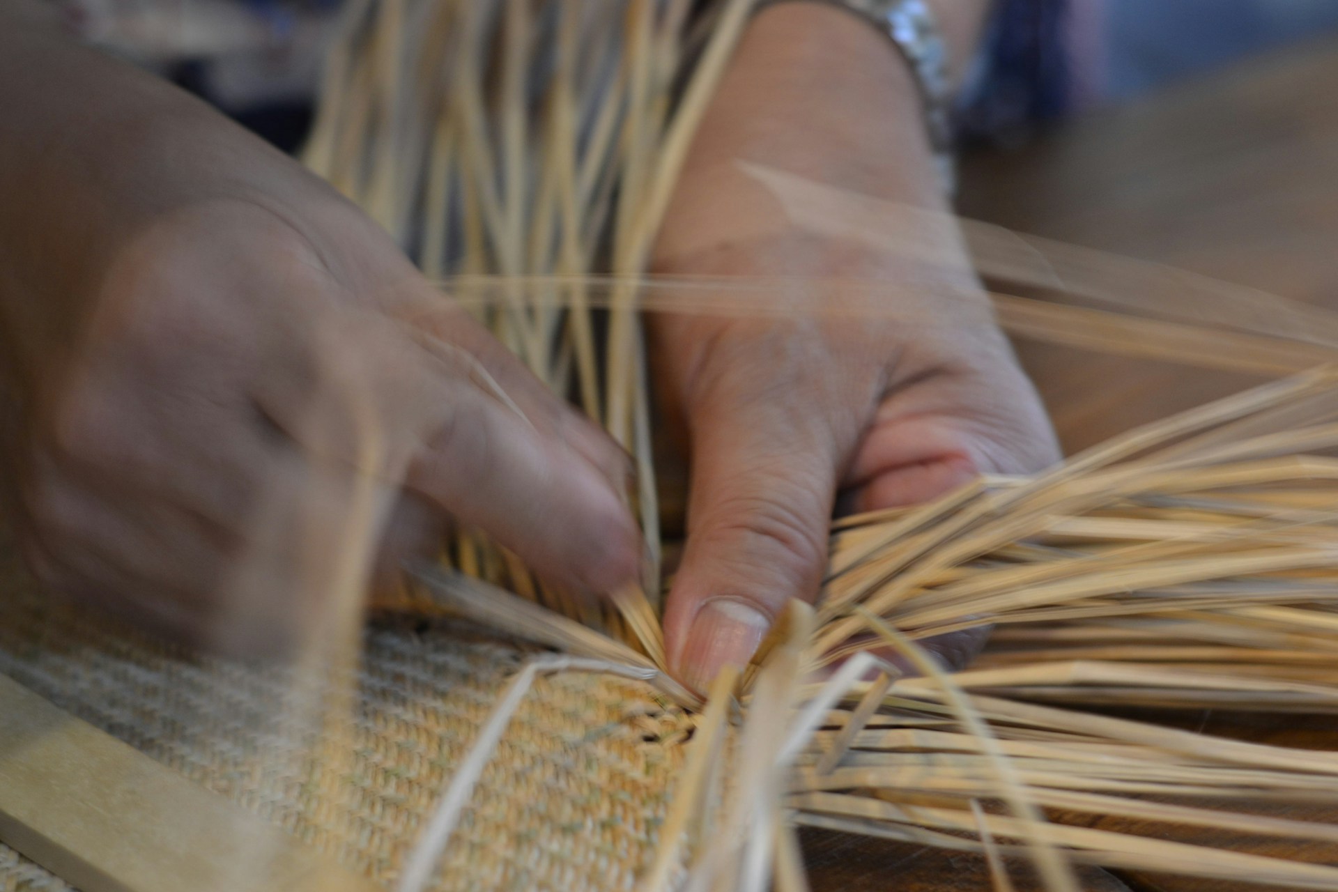A person weaving straw together, representing spiritually integrative therapy