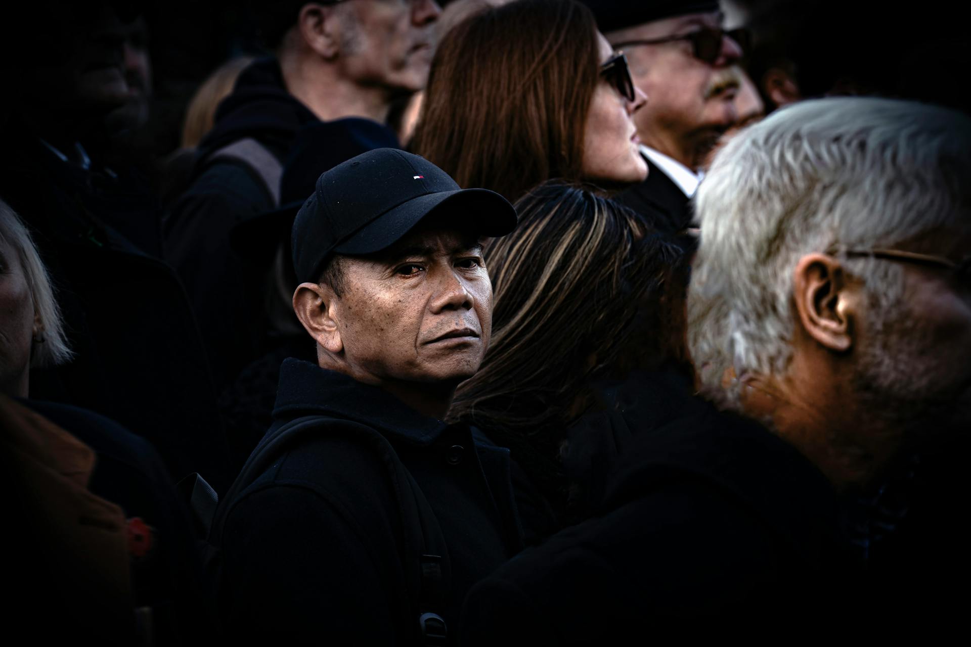 man looking empty in a crowd, with blank stare, portraying existential stagnation in mid-life