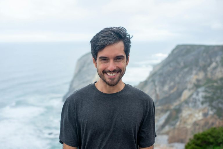 man smiling in front of ocean, symbolising existential growth in mid-life